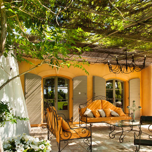 Idée de décoration pour une terrasse avant méditerranéenne avec des pavés en pierre naturelle et une pergola.