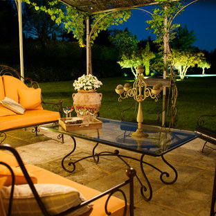 Esempio di un grande patio o portico mediterraneo davanti casa con pavimentazioni in pietra naturale e una pergola