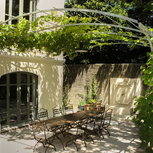 Exemple d'une grande terrasse avant méditerranéenne avec un point d'eau et une pergola.