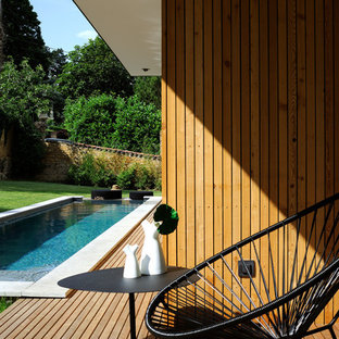 Exemple d'une terrasse arrière moderne de taille moyenne avec une extension de toiture.