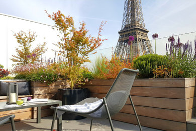 Cette image montre une grande terrasse arrière design avec une cuisine d'été, du carrelage et un auvent.