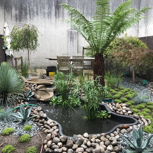 Immagine di un grande patio o portico etnico dietro casa con fontane, ghiaia e nessuna copertura