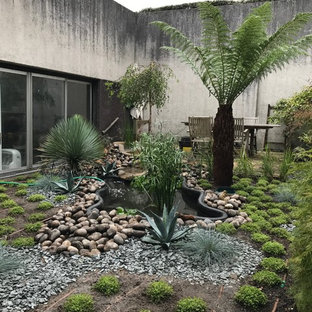 Ispirazione per un grande patio o portico etnico dietro casa con fontane, ghiaia e nessuna copertura
