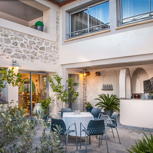 Cette photo montre une terrasse avec une cuisine extérieure méditerranéenne de taille moyenne avec une cour, des pavés en pierre naturelle et aucune couverture.