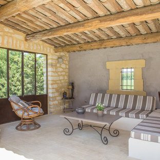 Inspiration pour une terrasse méditerranéenne de taille moyenne avec une extension de toiture, des pavés en pierre naturelle et une cheminée.