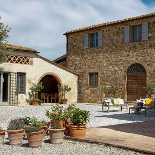 Foto di un patio o portico country dietro casa con ghiaia