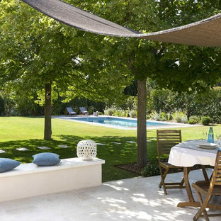 Aménagement d'une terrasse arrière méditerranéenne avec des pavés en pierre naturelle.