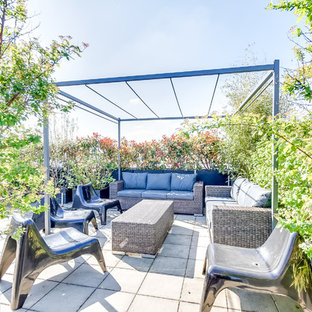 Idée de décoration pour une terrasse sur le toit design avec une pergola.