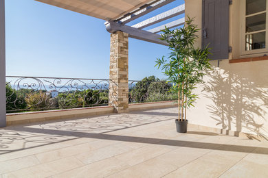 Réalisation d'une terrasse avec des plantes en pots avant design avec des pavés en pierre naturelle et un auvent.
