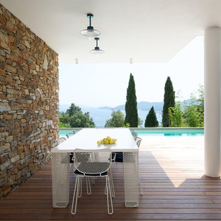 Cette image montre une grande terrasse arrière design avec une extension de toiture.