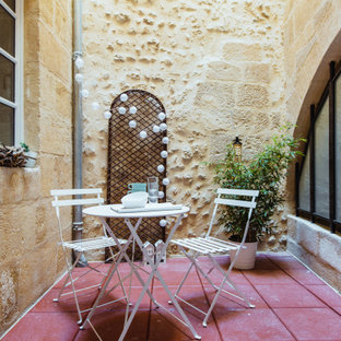 Idee per un piccolo patio o portico shabby-chic style dietro casa con piastrelle
