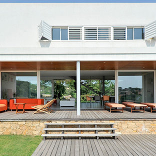 Exemple d'une grande terrasse arrière méditerranéenne avec une extension de toiture.