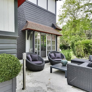 Inspiration pour une terrasse avec des plantes en pots arrière traditionnelle de taille moyenne avec aucune couverture et une dalle de béton.