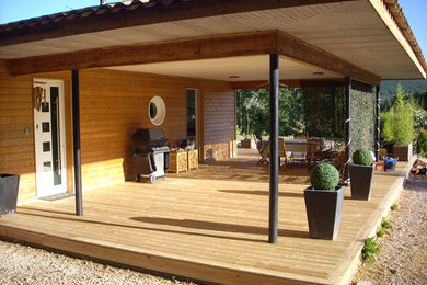 Cette photo montre une terrasse arrière tendance avec une extension de toiture.
