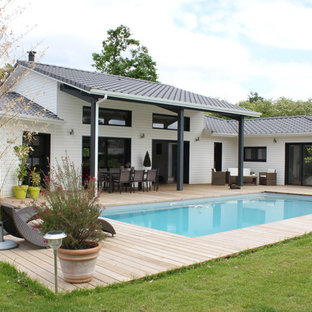 Cette image montre une terrasse arrière design avec une extension de toiture.