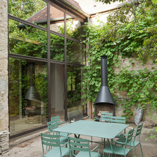 Photo of a small country courtyard patio in Dijon with no cover, concrete slab and with fireplace.