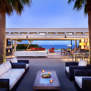 Idée de décoration pour une grande terrasse latérale design avec des pavés en béton et aucune couverture.