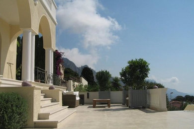 Inspiration pour une terrasse arrière méditerranéenne avec des pavés en pierre naturelle.