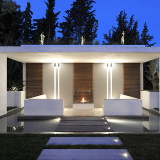 Cette image montre une terrasse arrière design de taille moyenne avec un gazebo ou pavillon et un foyer extérieur.