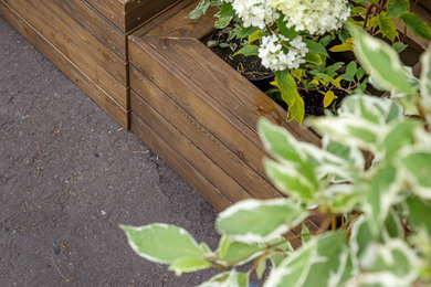 На фото: маленькая терраса в современном стиле с растениями в контейнерах для на участке и в саду