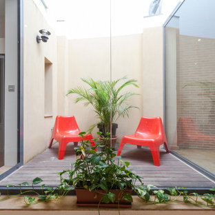 Design ideas for a small urban terrace in Seville with a potted garden and no cover.