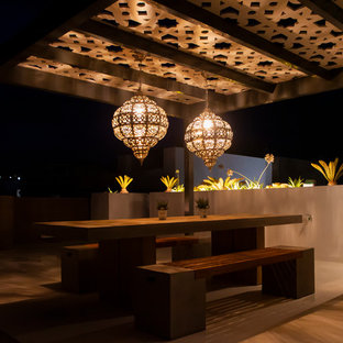 Example of a large trendy rooftop deck design in Malaga with a fireplace and a pergola