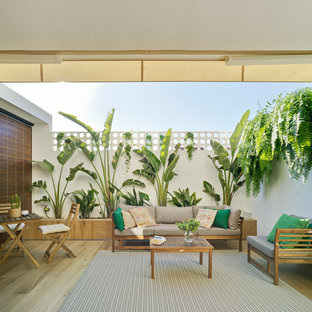 Imagen de terraza clásica, de tamaño medio, en patio trasero, con jardín vertical y toldo