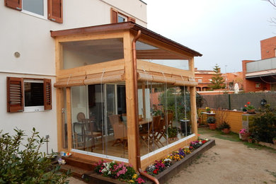 Modelo de terraza campestre pequeña en patio trasero con pérgola