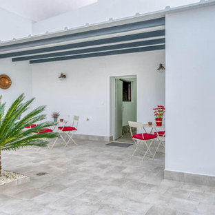 Idee per un ampio patio o portico bohémian dietro casa con un giardino in vaso, piastrelle e una pergola