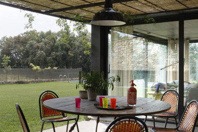Foto de terraza campestre de tamaño medio en patio trasero con losas de hormigón