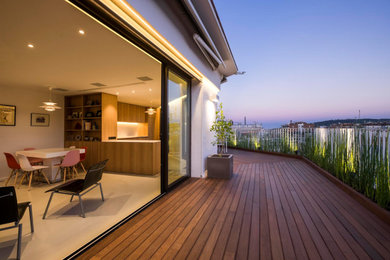 Diseño de terraza contemporánea de tamaño medio en azotea con jardín de macetas y toldo