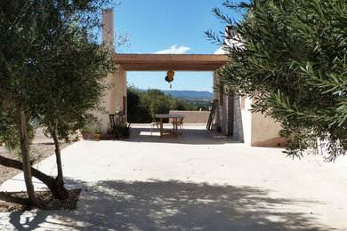 Modelo de terraza mediterránea de tamaño medio en patio lateral con pérgola