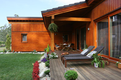 Diseño de terraza rural de tamaño medio en patio trasero y anexo de casas con entablado