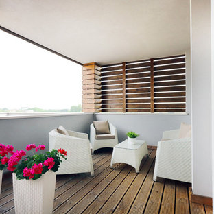 Ispirazione per una terrazza contemporanea con un giardino in vaso e un tetto a sbalzo