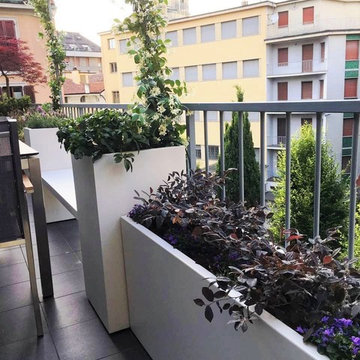 Terrazzo con fioriere, panca e arredi per una famiglia a Milano