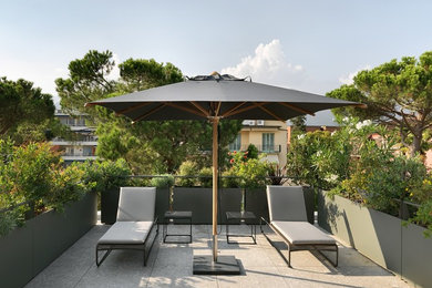 Immagine di un'ampia terrazza design sul tetto con un parasole