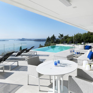 Idee per una grande terrazza design con un tetto a sbalzo