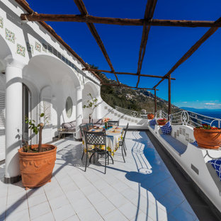 Idee per una grande terrazza mediterranea al primo piano con una pergola e parapetto in metallo