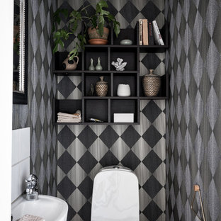 Exempel på ett minimalistiskt toalett, med en toalettstol med separat cisternkåpa, flerfärgade väggar, ett väggmonterat handfat och svart golv
