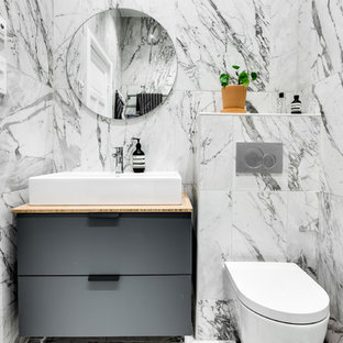 Idéer för att renovera ett litet skandinaviskt beige beige badrum, med släta luckor, grå skåp, en vägghängd toalettstol, grå kakel, vit kakel, flerfärgad kakel, ett fristående handfat och träbänkskiva
