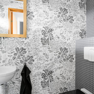 Inspiration för ett funkis toalett, med en vägghängd toalettstol, svart kakel, ett väggmonterat handfat och svart golv