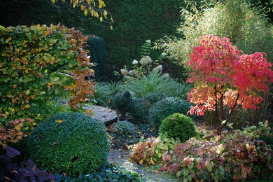 Foto de jardín contemporáneo de tamaño medio en otoño en patio trasero con exposición parcial al sol y adoquines de piedra natural