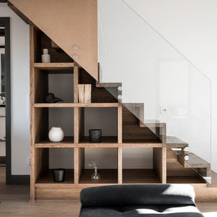 Esempio di una scala a rampa dritta scandinava con pedata in legno, alzata in legno e parapetto in vetro