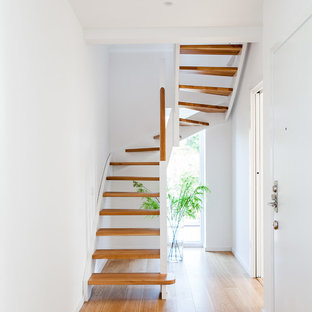 Aménagement d'un escalier sans contremarche scandinave en U avec des marches en bois.