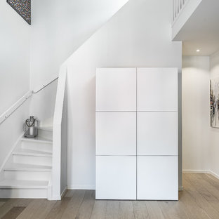 Inspiration för en minimalistisk svängd trappa i trä, med sättsteg i trä och räcke i trä