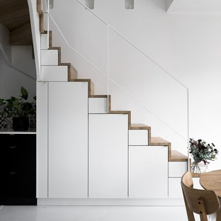 Esempio di una scala a "L" scandinava di medie dimensioni con pedata in legno e alzata in legno