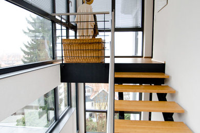 Ejemplo de escalera en U rústica pequeña sin contrahuella con escalones de madera y barandilla de metal