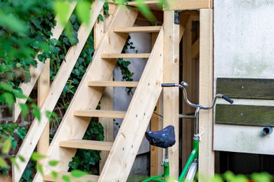 Ejemplo de escalera recta campestre pequeña con escalones de madera, contrahuellas de madera y barandilla de madera