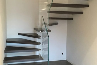 Foto de escalera moderna grande con escalones de madera y barandilla de vidrio