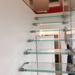 Immagine di una scala a rampa dritta design di medie dimensioni con pedata in vetro e parapetto in vetro